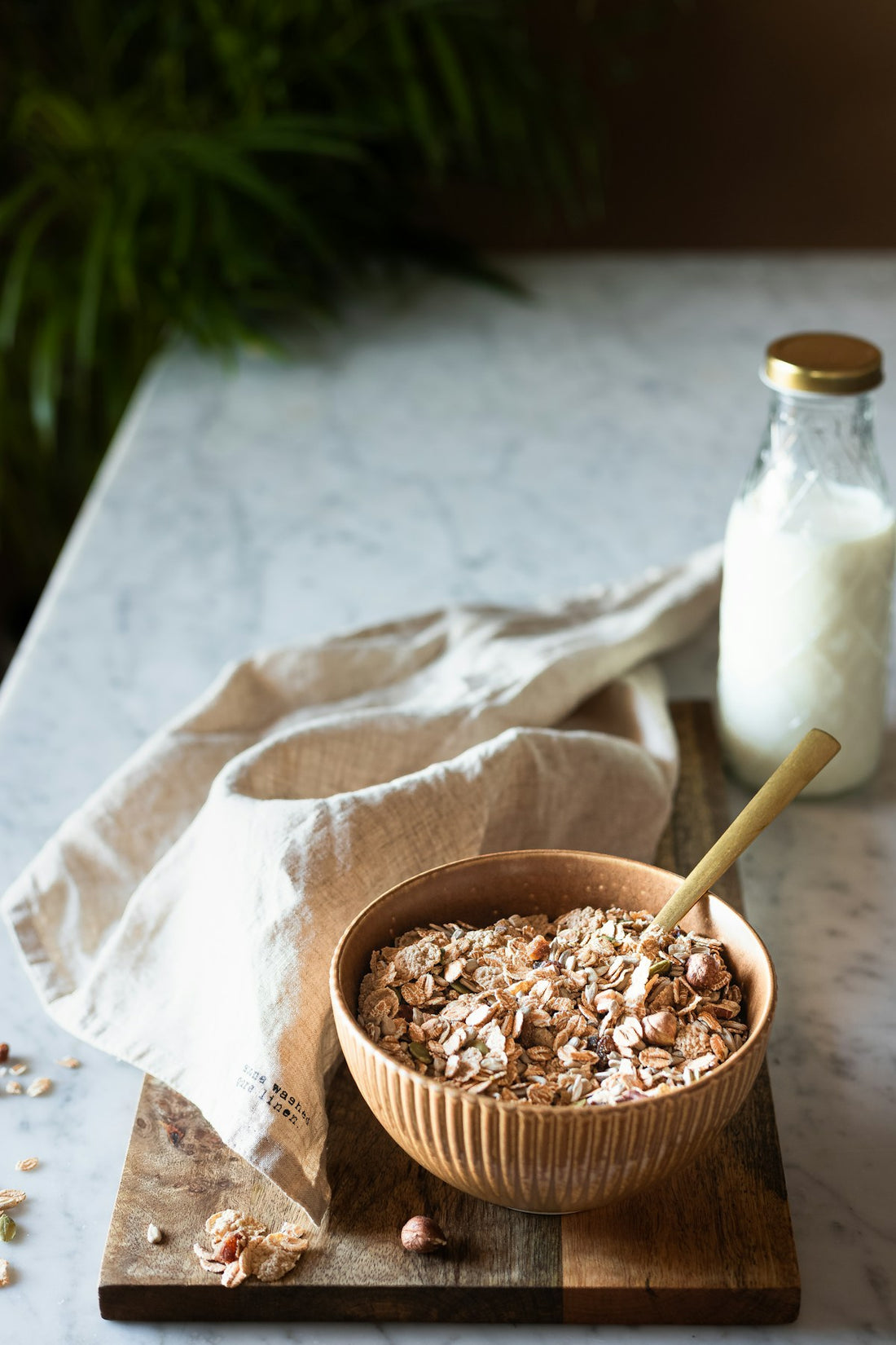 Brown wooden bowl filled with natural powder on a marble surface, representing maca and adaptogen supplements