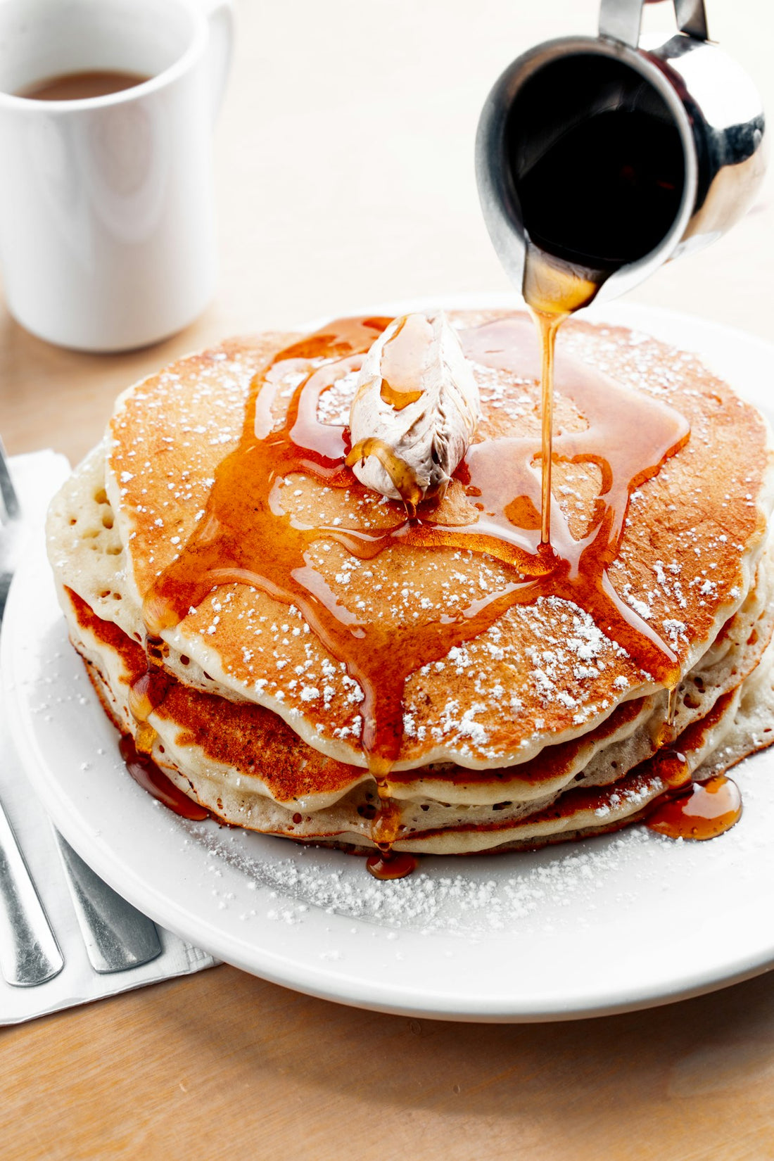 Dark syrup poured over a stack of pancakes, a common place to swap in yacon syrup