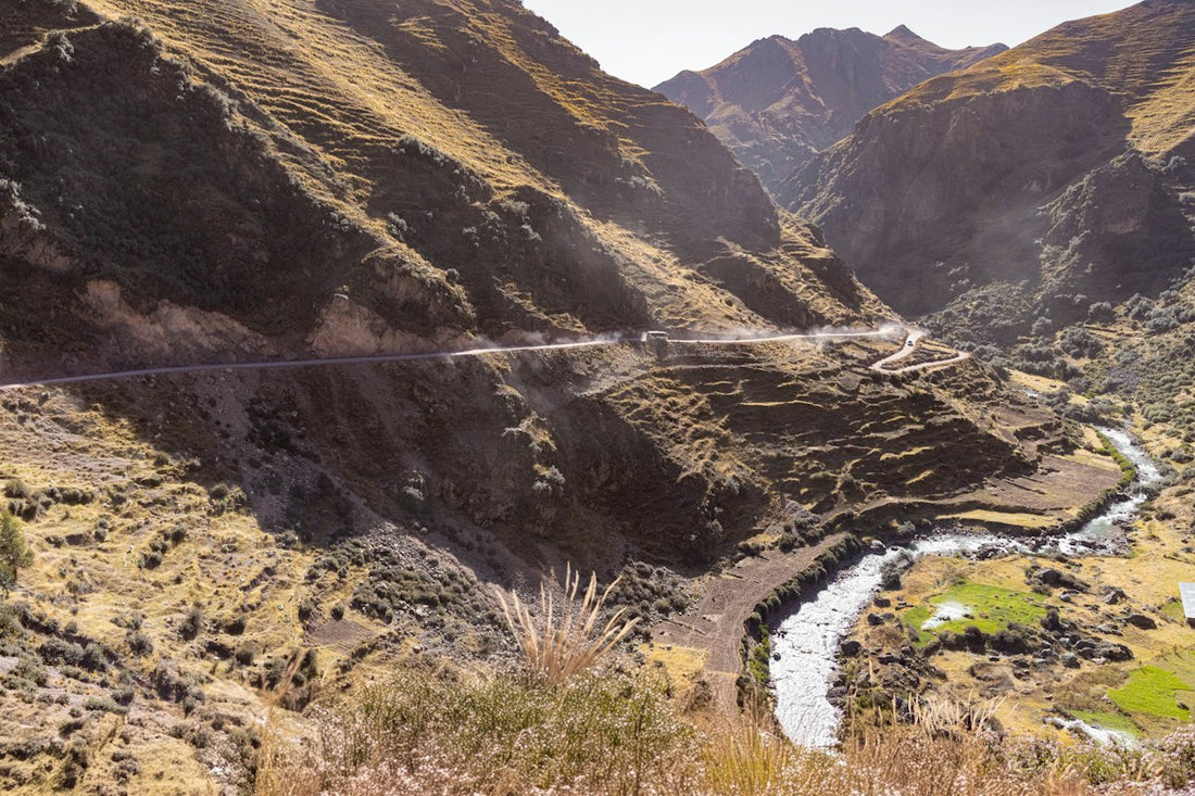 High Andean valley in Peru with a river and dry grass slopes, the kind of highland country where maca grows